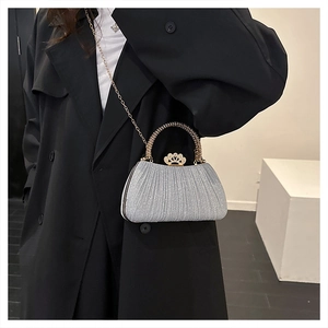 Detail of silver sequin evening bag with pleated texture and crown crystal clasp buckle