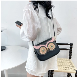 Sac bandoulière en forme de hibou avec yeux en strass porté par un mannequin