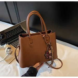 Brown litchi texture tote bag with teddy bear charm and scarf in office setting
