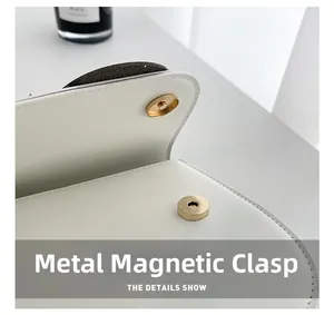 Détail du sac en cuir blanc avec fermeture magnétique dorée claire et coutures précises