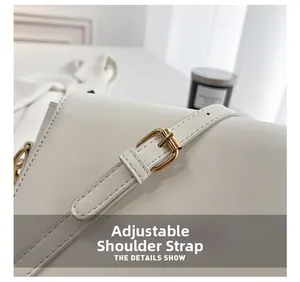Détail de la bandoulière réglable en similicuir blanc avec une boucle en métal doré