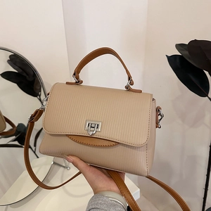 Chic two-tone textured crossbody bag in beige and brown with elegant silver clasp