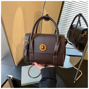 Detailed shot of dark brown vintage handbag featuring contrast stitching and golden hardware