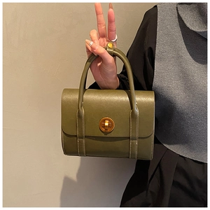 Detailed view of dark green retro leather handbag with vintage gold twist lock