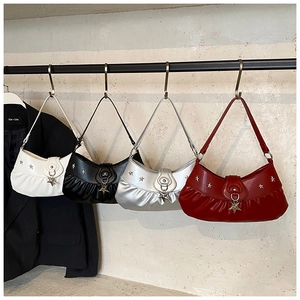 Detail of trendy pleated underarm bags in multiple colors with star-shaped metal charms