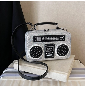 Detail of silver glitter radio box bag with vintage dials and black leather handle
