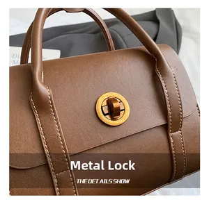 Detailed close-up of premium brown lychee texture leather with gold rotating lock