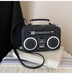 Detail of retro radio shaped glitter crossbody bag with FM dial and top handle strap