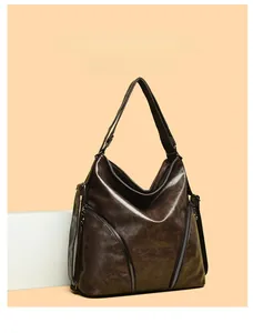 Detail of vintage dark brown faux leather hobo bag with decorative diagonal zippers
