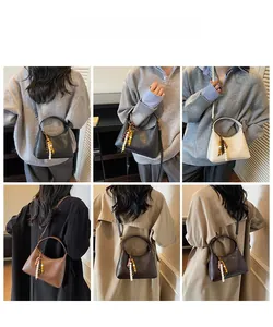 Détail du sac bandoulière croissant avec pompon en perles de bois et bandoulière