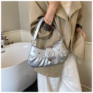 Close-up of silver pleated underarm bag with metallic star studs and star charm detail