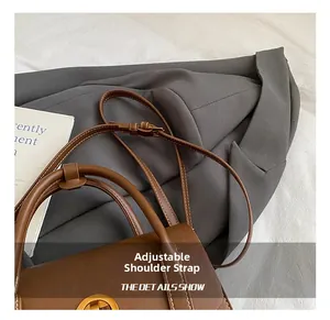 Detail of adjustable shoulder strap and gold hardware on brown vintage handbag