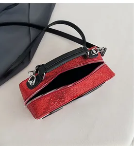 Detail of red sequin handbag showing the spacious interior compartment and dual zipper
