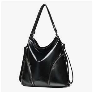 Close-up of glossy oil-waxed leather texture and dual metal zippers on large black bag