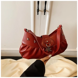 Detail of red pleated crescent shoulder bag with star rivets and metallic star pendant