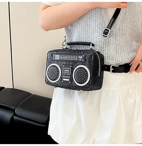 Detail of creative radio-shaped crossbody bag featuring black glitter and retro dials