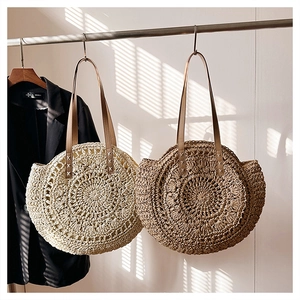 Detail of round straw woven handbags in cream and brown with spiral knit pattern