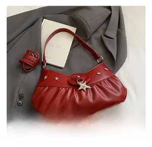 Detail of red ruched leather shoulder bag with star metal buckle and silver studs