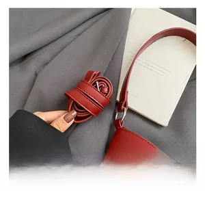 Close-up of red leather adjustable shoulder strap with star hardware and metal buckle