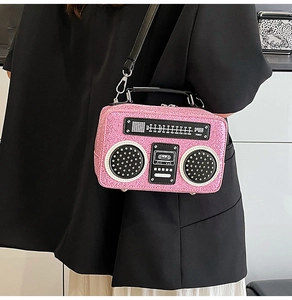 Close-up of pink sequined radio-shaped crossbody bag on a black blazer jacket