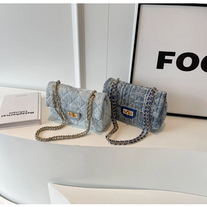 Detail of quilted denim chain bags featuring golden twist locks and metal strap textures