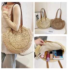 Detail of round straw tote bag showing spiral weave texture and leather straps in use