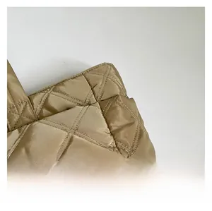 Close-up of champagne gold quilted fabric with premium diamond stitching texture