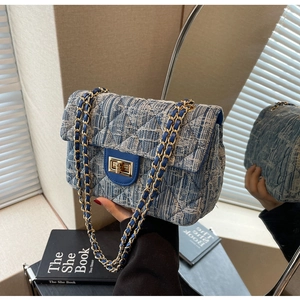 Detail view of blue and white tweed texture with classic quilted pattern and gold clasp