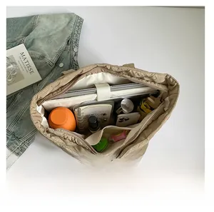 Internal view of quilted tote bag showing large capacity and dedicated laptop compartment