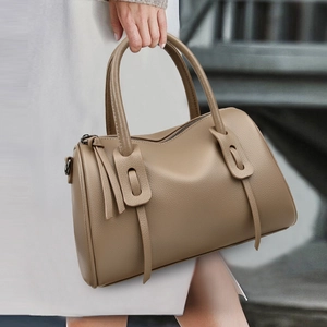 Detail der braunen Boston-Tasche aus Litchi-Leder mit Griffen und Fransenakzenten