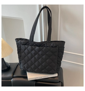 Macro detail of black quilted tote bag texture with high density nylon stitching