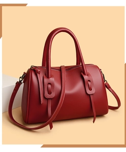 Detailansicht rote Boston Bag aus genarbtem Leder mit bronzefarbenen Metallteilen