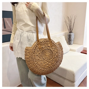 Macro shot of circular woven straw bag texture with brown leather strap detail
