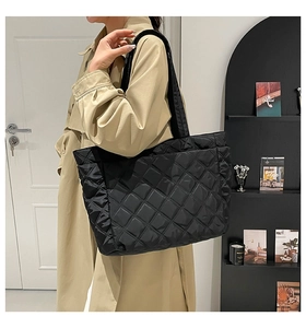 Detail of black quilted tote bag with diamond stitching on high-density nylon fabric