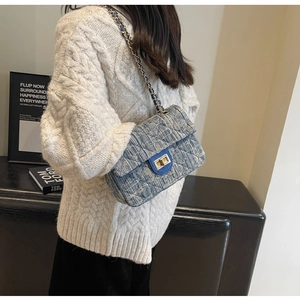 Close-up of blue tweed chain bag with diamond quilting and gold metallic lock detail