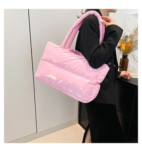 Detailed view of pink glossy padded tote bag with thick handles and puffy fabric texture