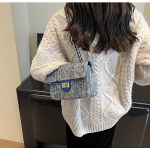 Blue quilted chain bag detail showing textured canvas and elegant metal twist lock closure