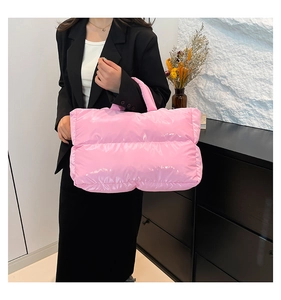 Detail of pink quilted puffer handbag with glossy finish and soft padded texture
