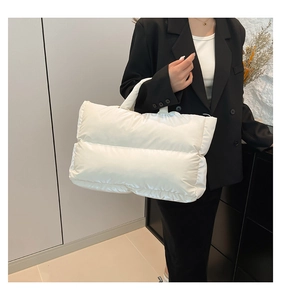 Close-up of white quilted down-filled tote bag with horizontal pleated nylon texture