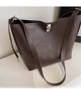 Detail view of the deep coffee tote bag showing PU leather texture and silver swivel lock