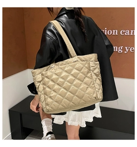 Quilted tote bag detail showing side pocket and spacious design on female model