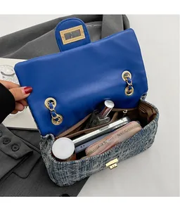 Detail of tweed and leather crossbody bag showing interior capacity and golden chain