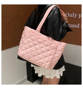 Detailed view of pink quilted nylon tote bag with rhombus pattern on female model