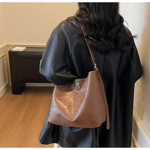 Detail of vintage brown hobo bag featuring a square silver metallic buckle and wide strap