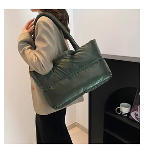 Detail of dark green quilted tote bag showing padded texture and spacious shoulder design