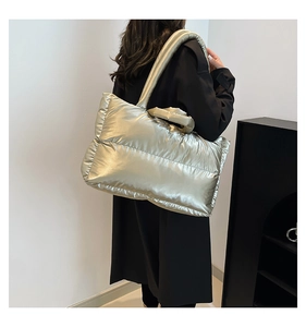 Detail of champagne silver quilted puffer bag with metallic finish and wide shoulder strap
