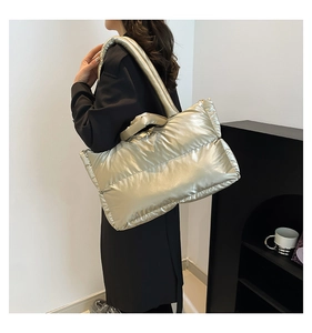 Macro view of champagne gold quilted tote bag showing padded texture and large size