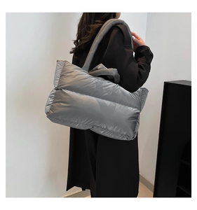 Close-up of metallic silver quilted padded tote with thick shoulder strap detail