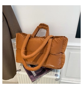 Detail of padded quilted puffer tote in caramel brown with dual shoulder straps