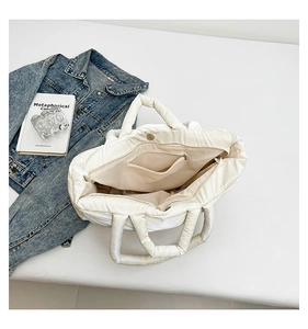 Interior view of large off-white quilted puffer tote bag with a zipper pocket